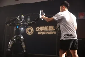 URKL T800 robot training with focus mitts alongside a human coach in the EngineAI gym