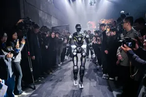 URKL T800 robot walking down the tunnel toward the arena through a crowd
