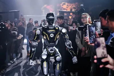 URKL T800 robot walking out through a crowd of photographers and reporters