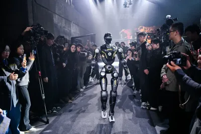 URKL T800 robot walking down the tunnel toward the arena through a crowd
